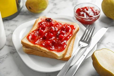Slice of bread with jam on white marble table Stock Photos