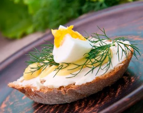 Slice of bread with mustard and cheese sauce and egg Stock Photos
