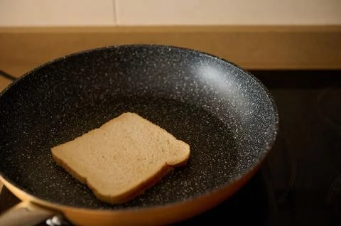 Slice Of Bread In A Nonstick Pan On A Warm Kitchen Stove Stock Photos