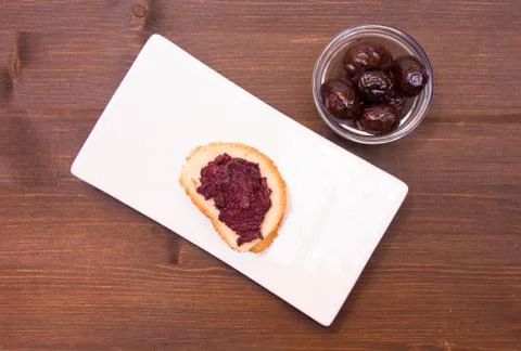 Slice of bread with olive paste on wooden table top view Stock Photos