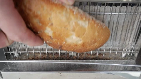 Slice of bread is placed on vertical electric toaster seen from close up. Stock Footage 341530137