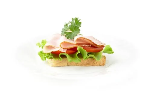 Slice of bread on plate with lettuce,cold cuts with parsley on white backgrou Stock Photos