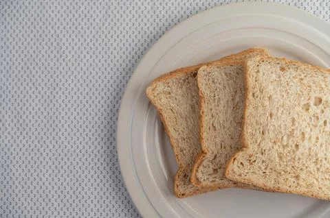 A slice of bread on a plate on a white background Stock Photos