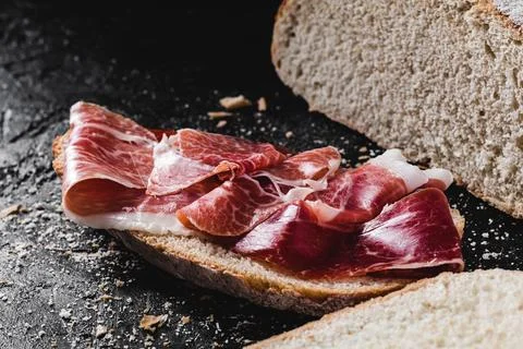 Slice of bread seasoned with serrano ham Foto stock