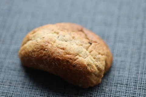 A slice of bread sits alone on a table, perfect for a still life or food Stock Photos