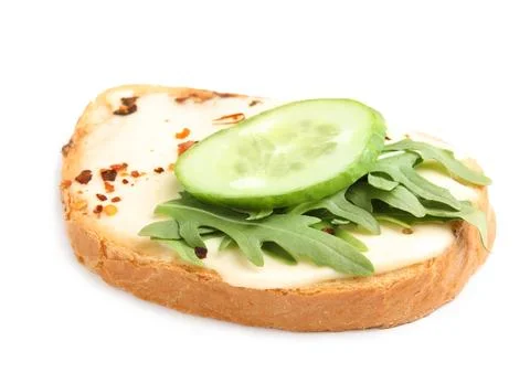 Slice of bread with spread, cucumber and arugula on white background Stock Photos
