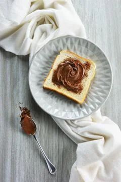 Slice of bread spread with hazelnut praline paste Stock Photos
