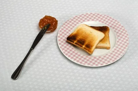 Slice of bread spread with jam Slice of bread spread with jam and knife on... Stock Photos