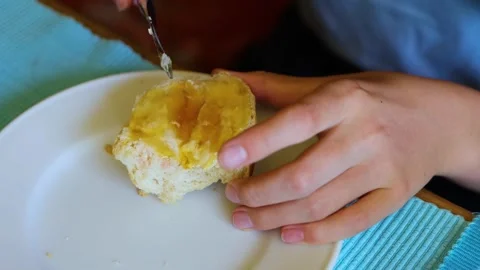 A slice of bread topped with butter and honey being poured. Young womans is.. Stock-Footage 287245376