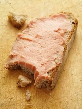 A slice of bread topped with teewurst with a bite taken out Foto stock