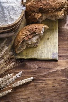 Slice of bread with wheat ears and flour in bucket on old wooden board 스톡 사진
