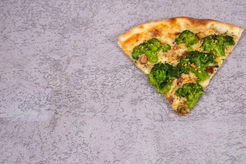 Slice of broccoli pizza on gray background with space for text. top view Stock Photos