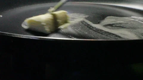 The slice of butter thaws on a frying pan Stock Footage 25719631