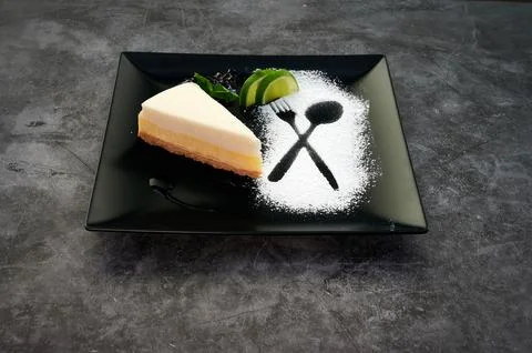 A slice of cake with a fork and spoon on top of it Stock Photos