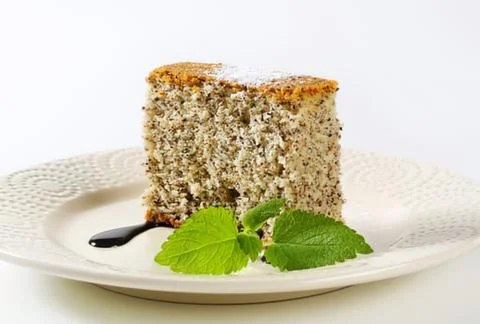 Slice of cake with mint leaves on white plate Stock Photos