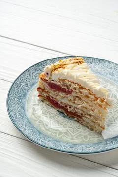 Slice of cake on patterned plate with wooden table background Stock Photos