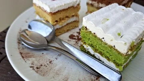 A slice of cake on a plate with a fork and spoon Foto stock