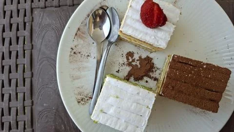 A slice of cake on a plate with a fork and spoon Foto stock