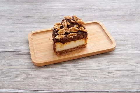 A slice of cake with walnuts on top Stock Photos