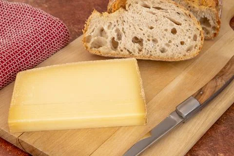 Slice of cantal cheese and bread close-up on a cutting board Stock Photos