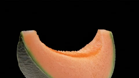 Slice of cantaloupe melon rotating. Isolated on black background. Stock Footage 169863214