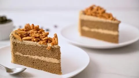 Slice of caramel cake with nuts on a white plate Stock Photos