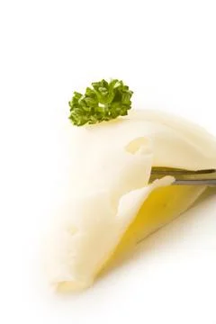 Slice of cheese with parsley on fork Stock Photos