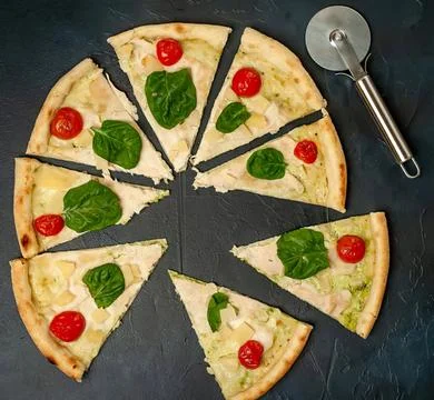 Slice of cheese pizza with tomatoes and basil on black plate Stock Photos