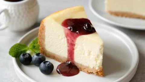 Slice of cheesecake with blueberry sauce Stock Photos