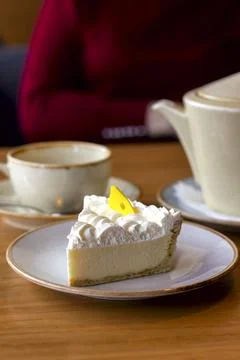 Slice of cheesecake with a cup of tea on the table in a cafe Stock Photos