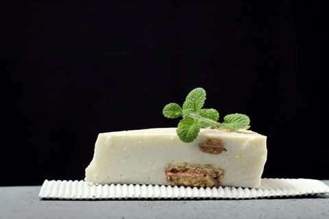 Slice of cheesecake on a gray background,fragrant sprig of mint 스톡 사진
