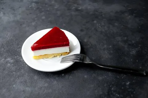 Slice of cherry cheesecake on a white plate with fork Stock Photos