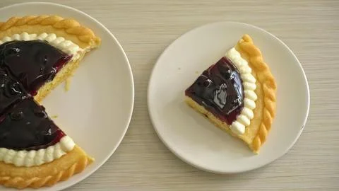 Slice of cherry pie on a white plate with a second piece nearby Stock Photos