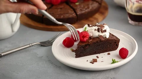 Slice of chocolate brownie cake topped with fresh raspberries Stock Footage 242524632
