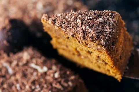 Slice of a chocolate cake raised up. Close up shot Stock Photos