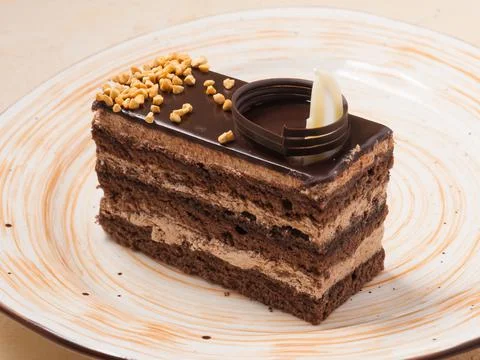 Slice of chocolate sponge cake decorated with nuts Stock Photos