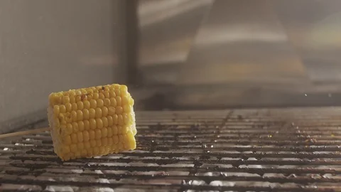 Slice of corn falls on the grill. Charcoal fried corn. Slow motion video Stock Footage 123787996