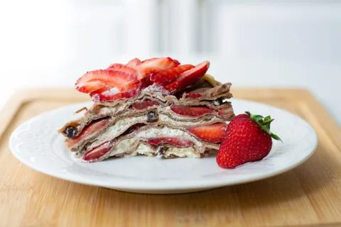 A slice of crepe layer cake with whipped cream and strawberry Stock Photos