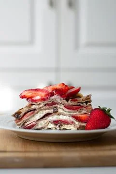 A slice of crepe layer cake with whipped cream and strawberry Stock Photos