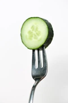 Slice of cucumber on a fork Stock Photos