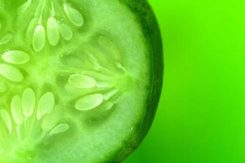 A slice of cucumber on a green background. copy space for skin care products  Foto stock