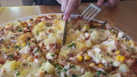 A slice is cut off from a big tasty pizza Stock Footage 104778660