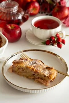 Slice of delicious apple strudel served with hot tea and fresh apples on a .. Stock Photos