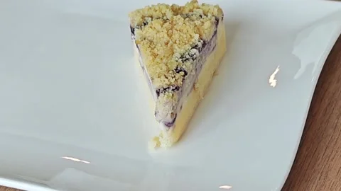 A slice of delicious blueberry crumble cake on a white plate. Vidéo 344747363