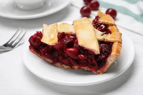 Slice of delicious fresh cherry pie on white wooden table, closeup Stock Photos