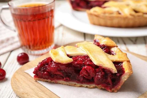 Slice of delicious fresh cherry pie on wooden board, closeup Stock Photos