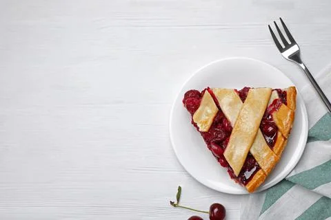 Slice of delicious fresh cherry pie served on white wooden table, flat lay. S Stock Photos
