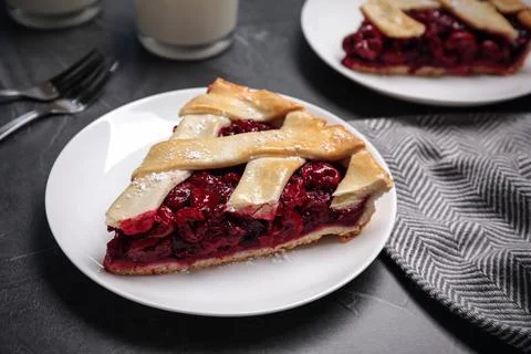 Slice of delicious fresh cherry pie on grey table, closeup Stock Photos