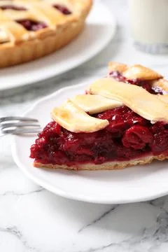 Slice of delicious fresh cherry pie on white marble table, closeup Stock Photos
