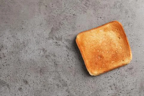 Slice of delicious toasted bread on gray table, top view. Space for text Stock Photos